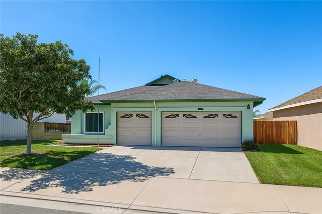 a front view of a house with a garden and garage