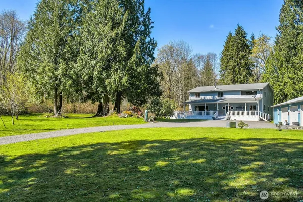 a view of a house with a big yard and sitting area