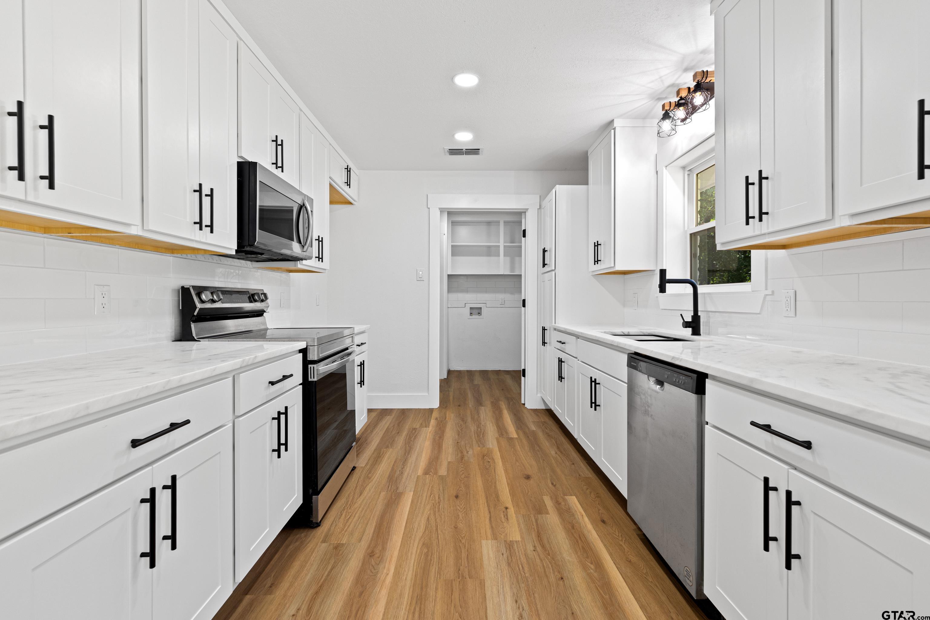 1907 Beth Drive Longview, TX 75605 - Photo 11 of 39 a kitchen with white cabinets sink and stainless steel appliances