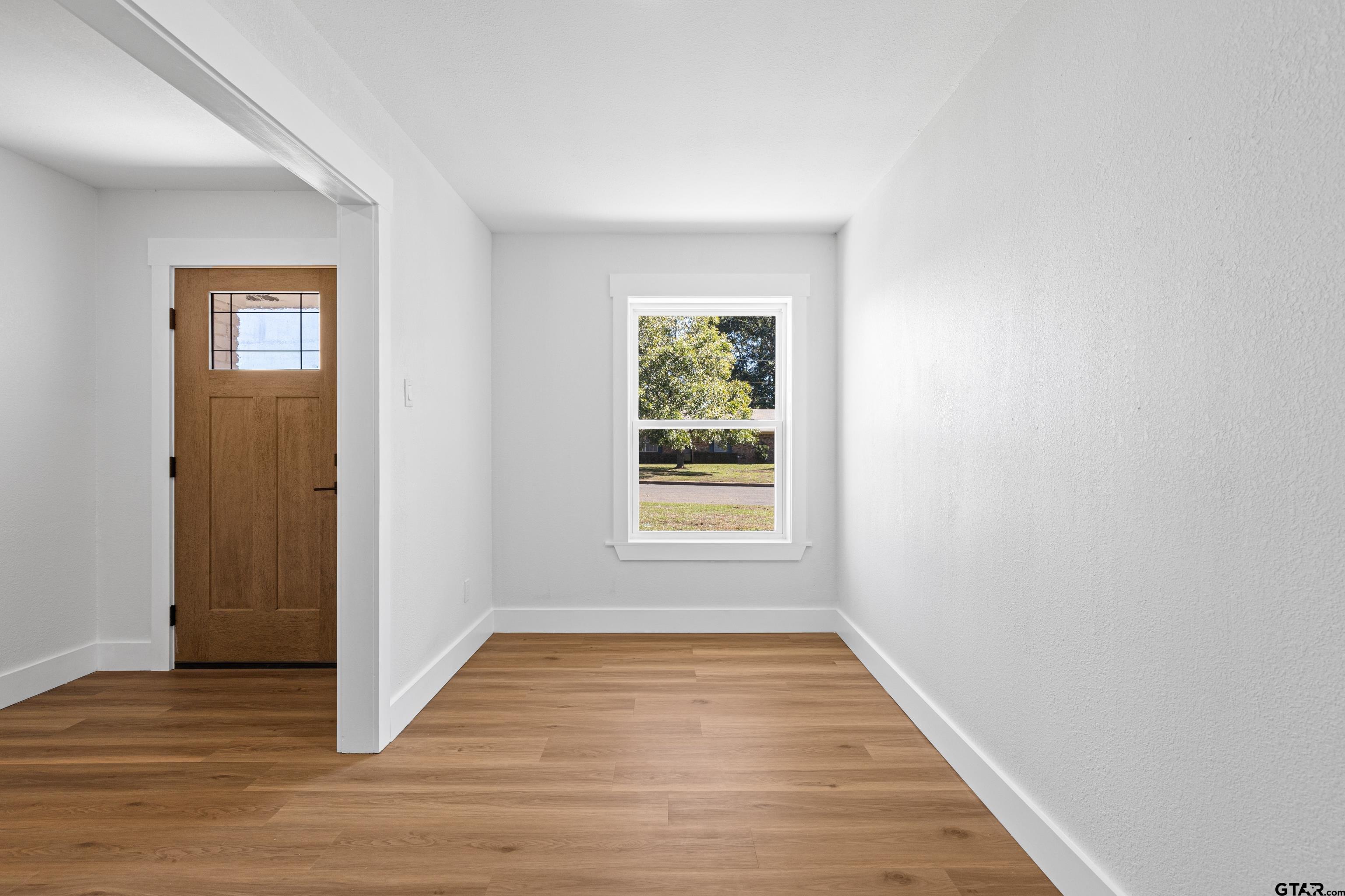 1907 Beth Drive Longview, TX 75605 - Photo 17 of 39 a view of an empty room with wooden floor and a window