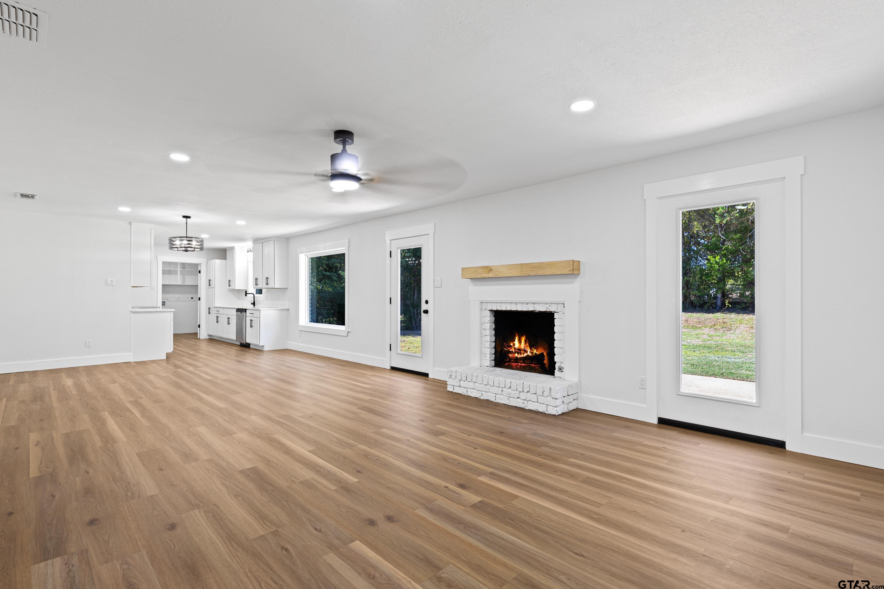 1907 Beth Drive Longview, TX 75605 - Photo 19 of 39 an empty room with wooden floor a fireplace and window