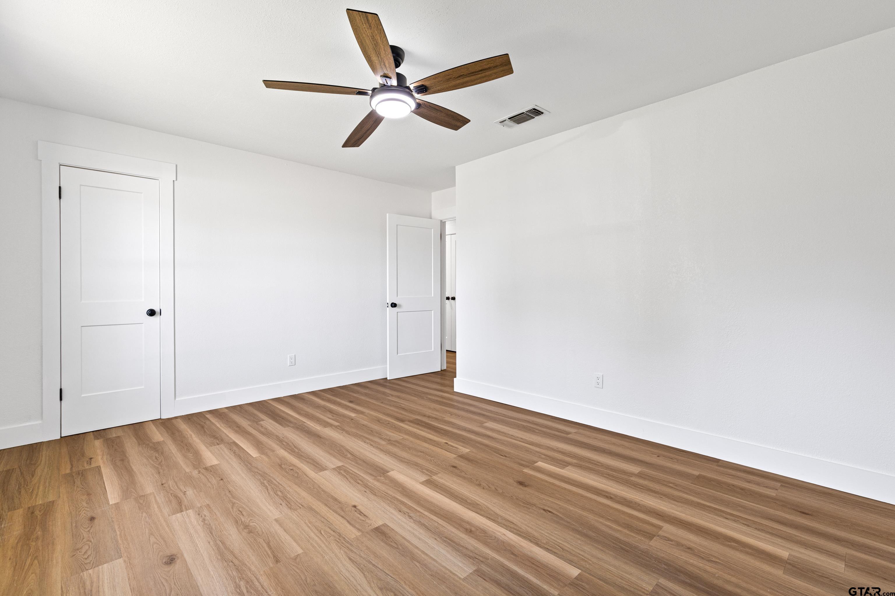 1907 Beth Drive Longview, TX 75605 - Photo 27 of 39 an empty room with wooden floor fan and windows