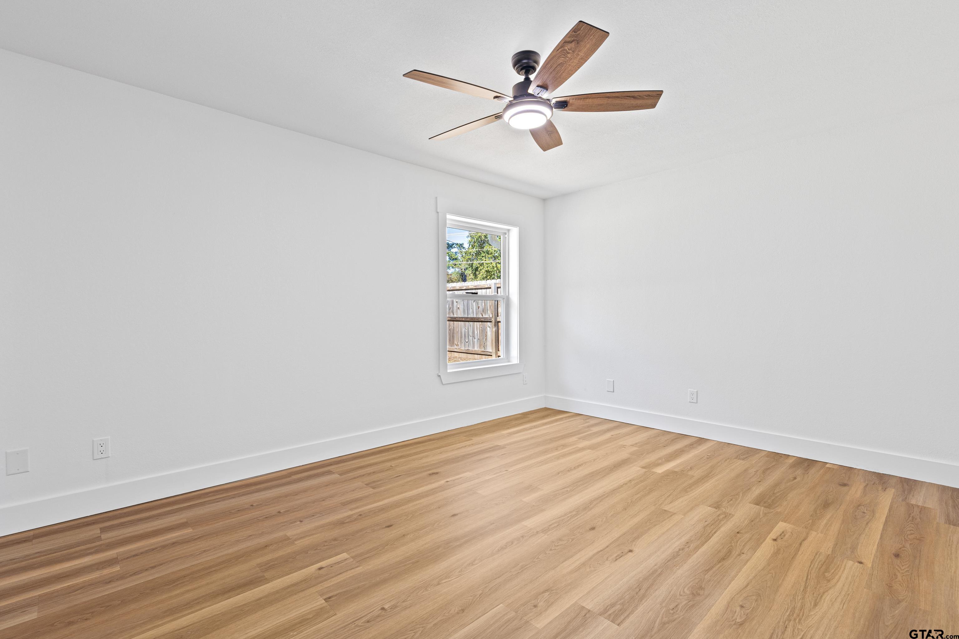 1907 Beth Drive Longview, TX 75605 - Photo 28 of 39 an empty room with wooden floor ceiling fan and window