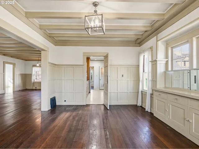 a view of a hallway with wooden floor and chandelier