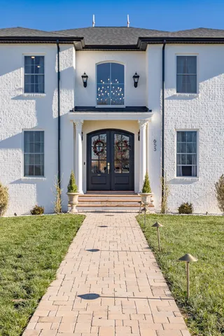 a view of a hallway with wooden floor and a living room