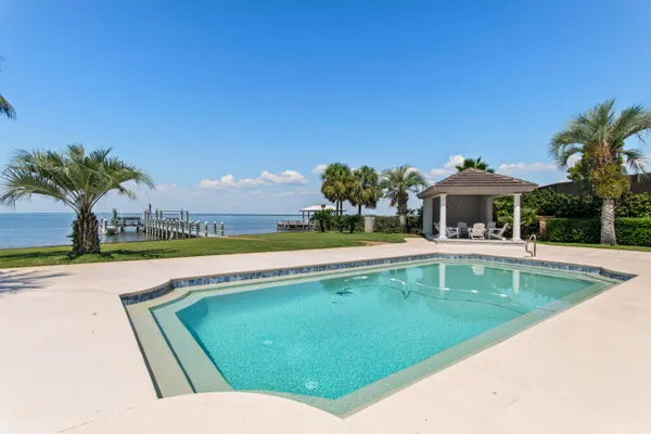 a view of a house with swimming pool and a yard