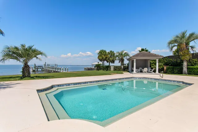 a view of a house with swimming pool and a yard