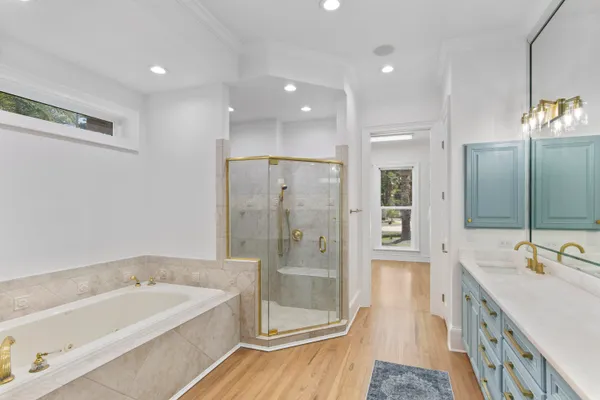 a spacious bathroom with a tub sink shower and mirror