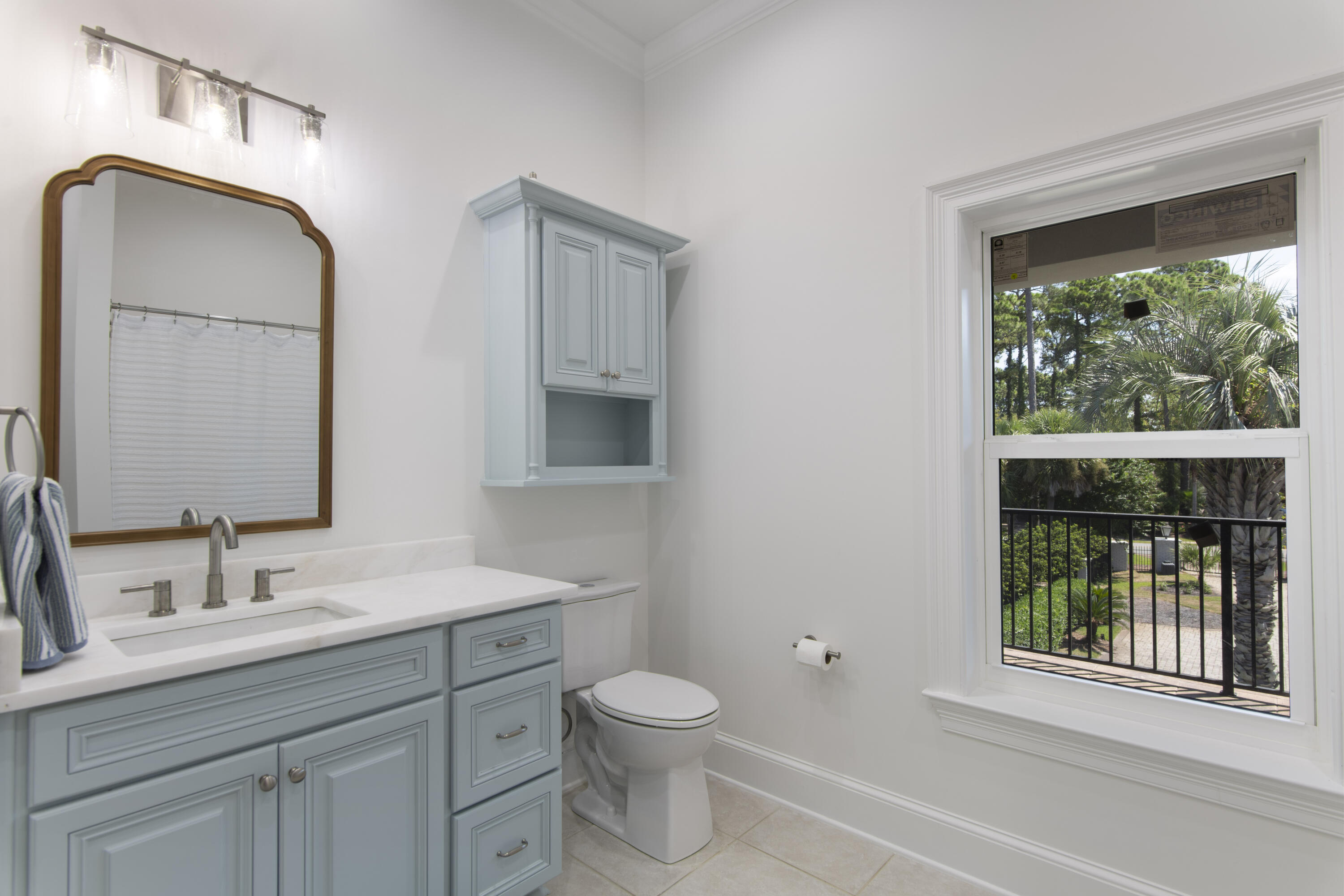 671 Driftwood Point Road Santa Rosa Beach, FL 32459 - Photo 27 of 41 a bathroom with a toilet a sink a mirror and next to a window