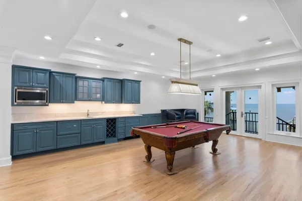 a kitchen with stainless steel appliances granite countertop a refrigerator a sink dishwasher a dining table and chairs with wooden floor