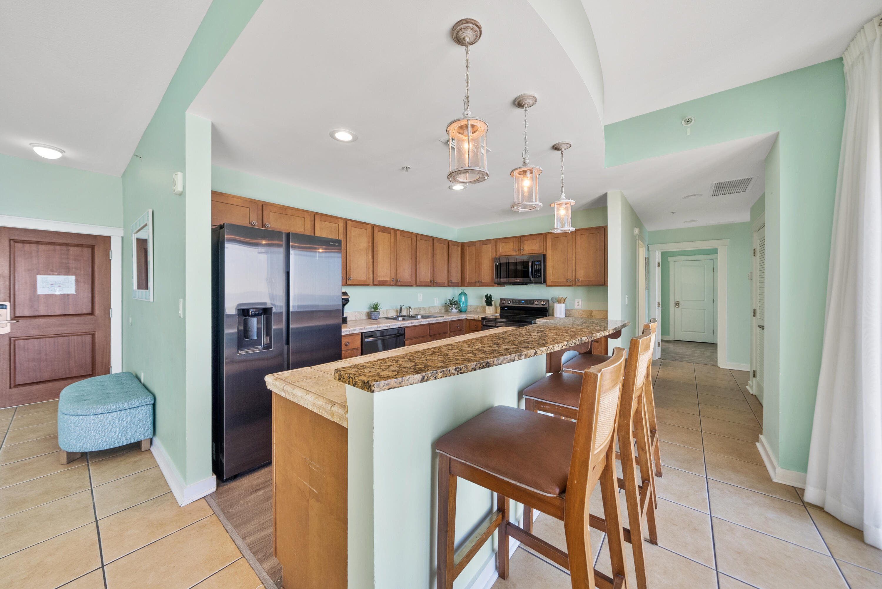 15100 Front Beach Road, Unit 1604 Panama City Beach, FL 32413 - Photo 13 of 66 a kitchen with stainless steel appliances kitchen island granite countertop a refrigerator and microwave