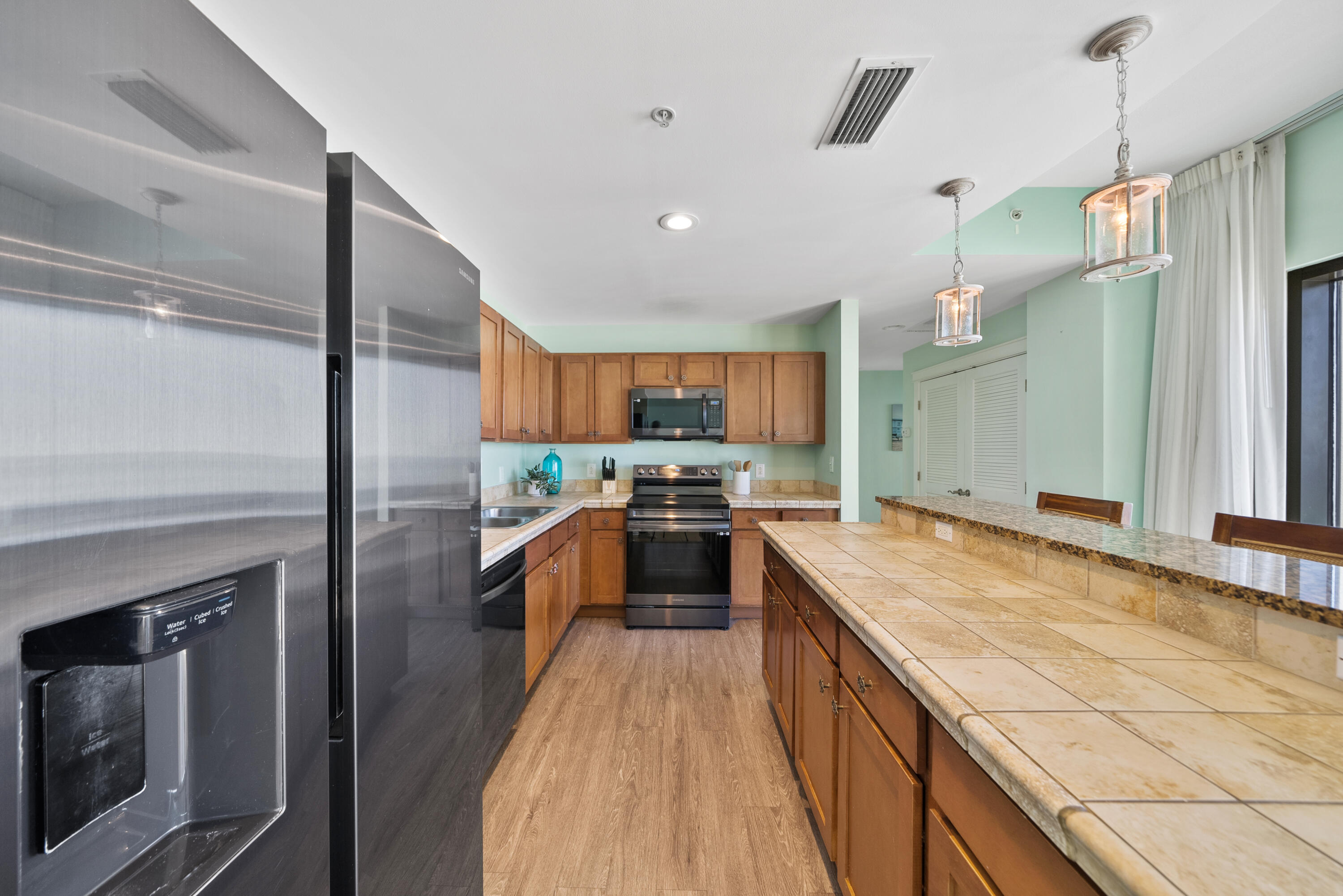 15100 Front Beach Road, Unit 1604 Panama City Beach, FL 32413 - Photo 14 of 66 a large kitchen with stainless steel appliances granite countertop a large counter top and a stove