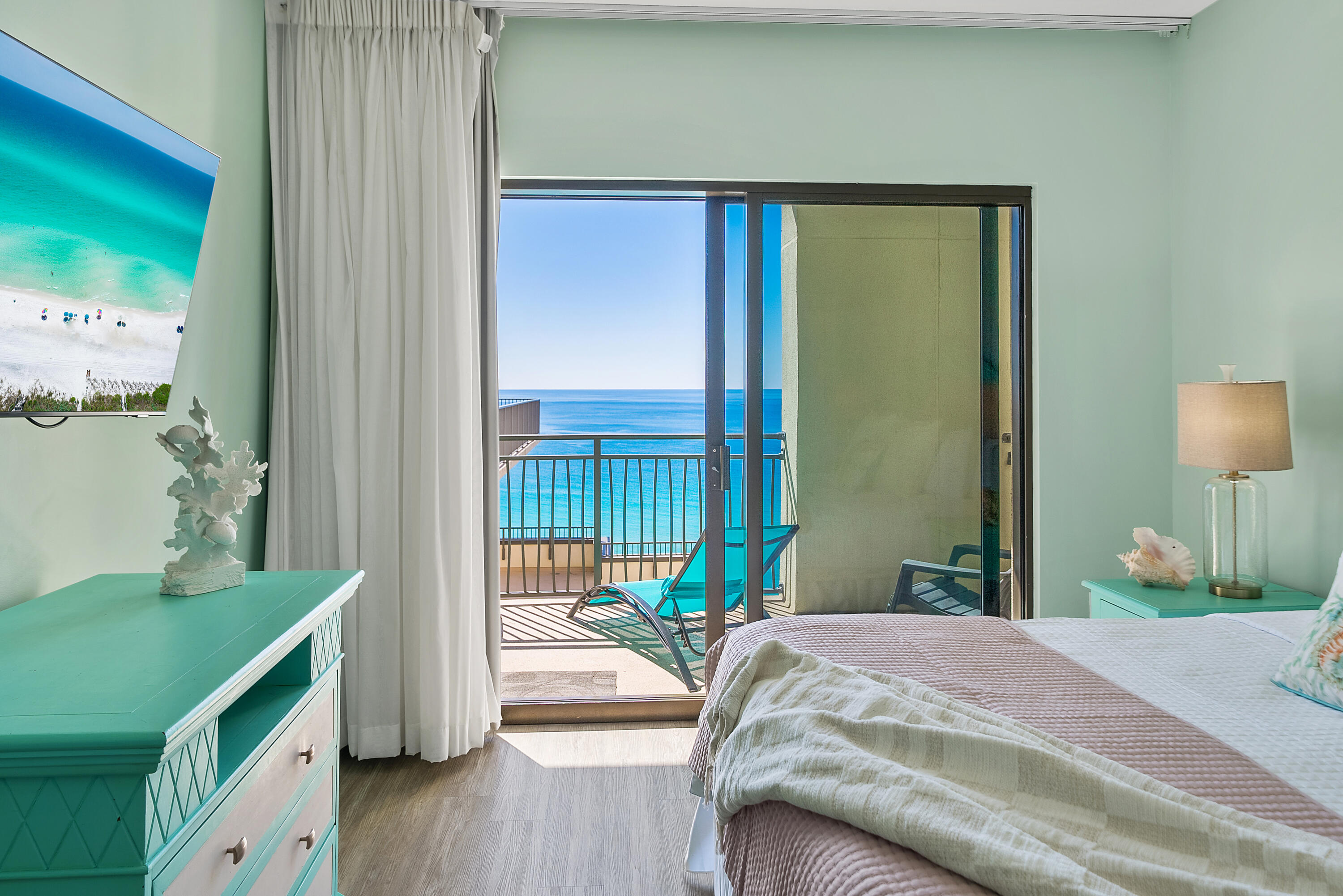 15100 Front Beach Road, Unit 1604 Panama City Beach, FL 32413 - Photo 22 of 66 a bedroom with a bed and a dresser next to a window