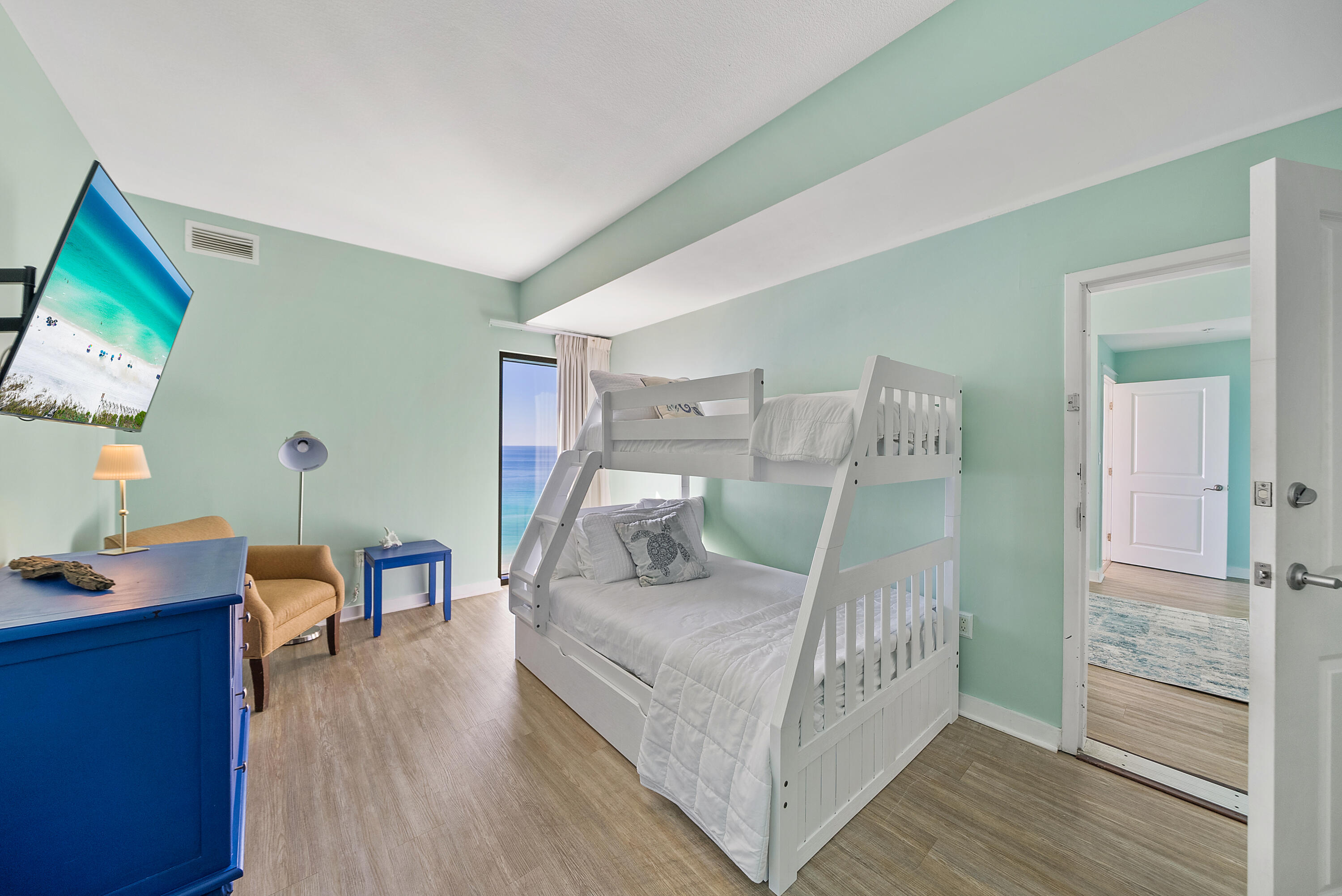 15100 Front Beach Road, Unit 1604 Panama City Beach, FL 32413 - Photo 44 of 66 a bedroom with furniture and a wooden floor