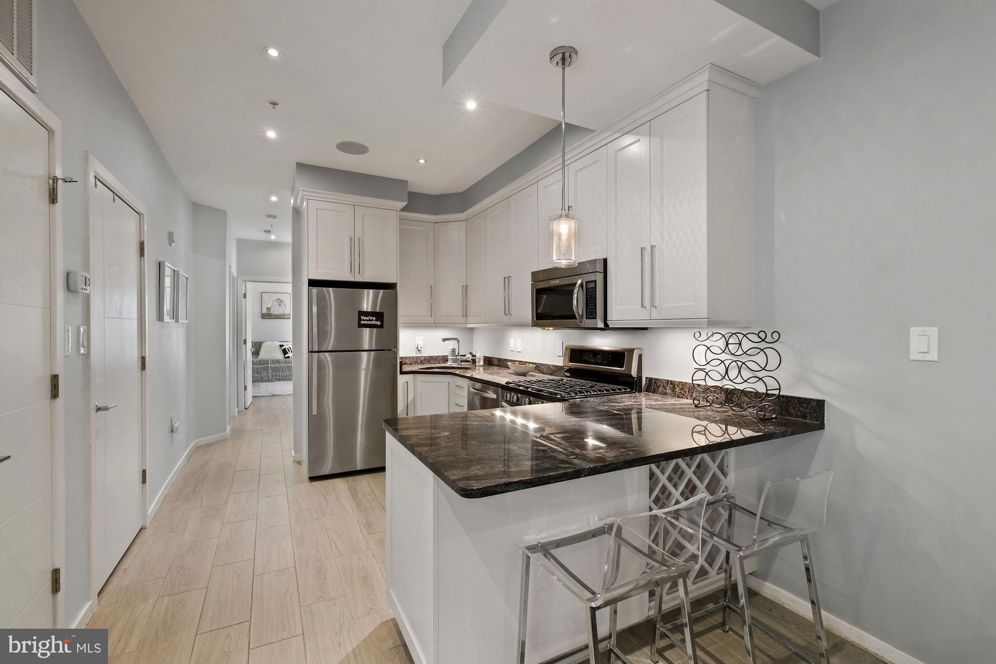756 Park Road Northwest, Unit 2 Washington, DC 20010 - Photo 10 of 48 a kitchen with stainless steel appliances granite countertop a sink a stove a refrigerator and island with wooden floor