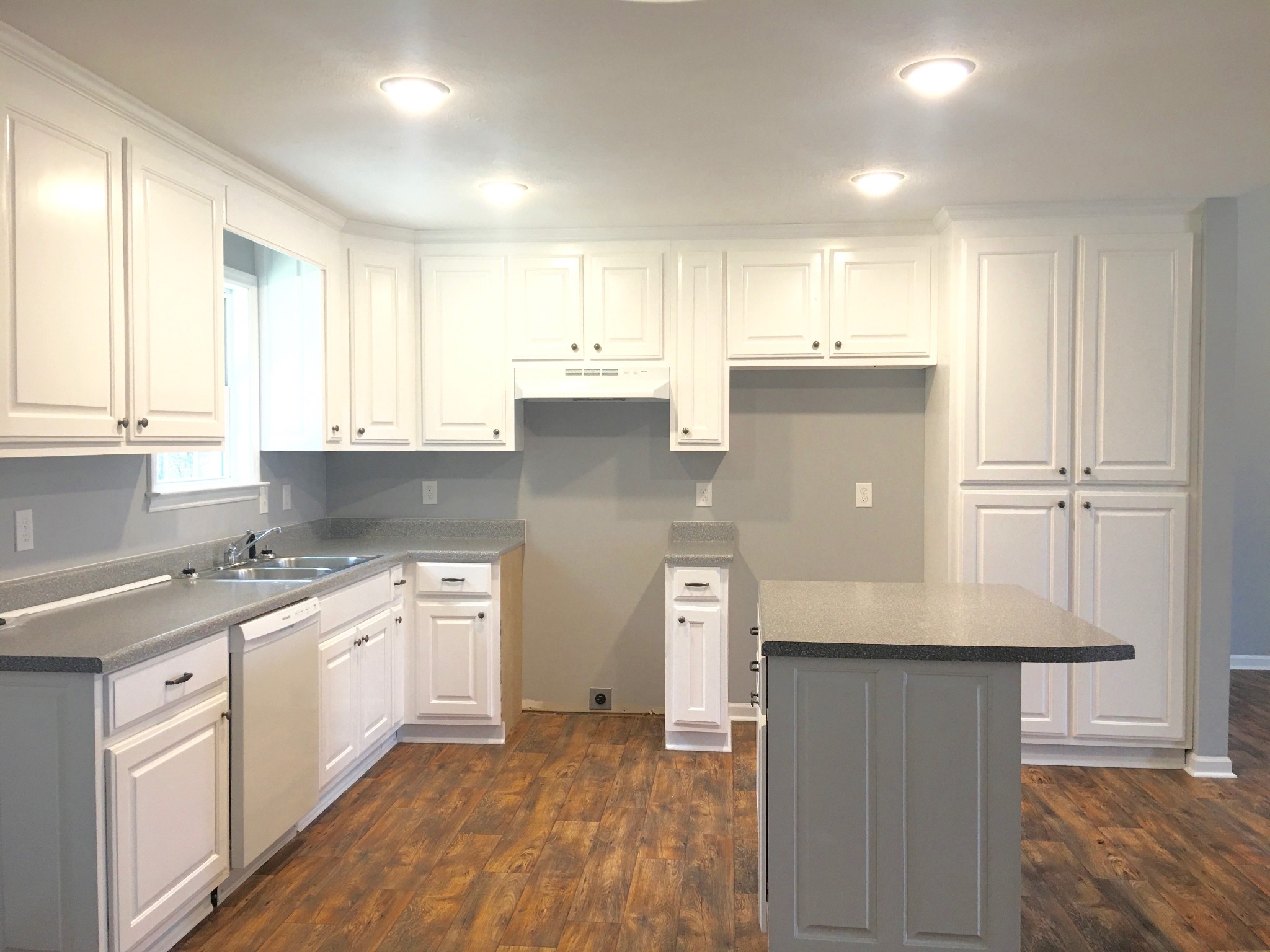 45 Cecil Johnson Road Mulberry, TN 37359 - Photo 4 of 12 a kitchen with stainless steel appliances granite countertop a refrigerator a sink dishwasher and white cabinets with wooden floor