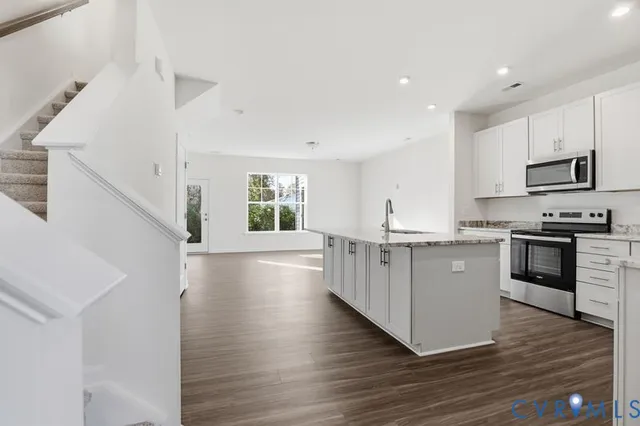 a kitchen with granite countertop a stove top oven and cabinets