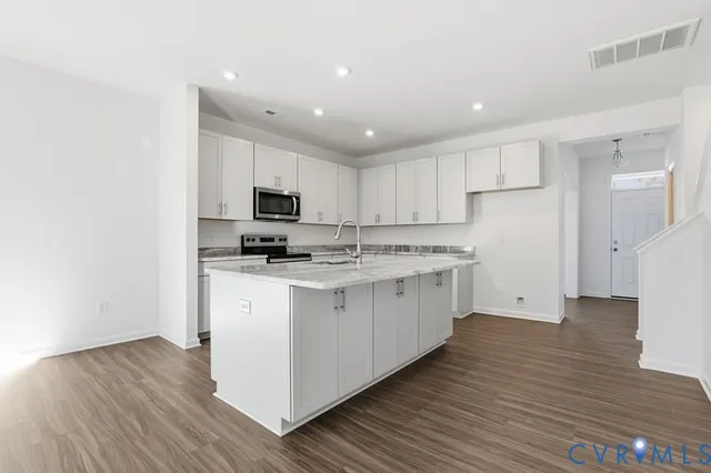a kitchen with stainless steel appliances granite countertop a stove a sink and a refrigerator