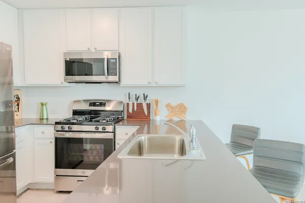 a kitchen with stainless steel appliances a refrigerator sink and microwave