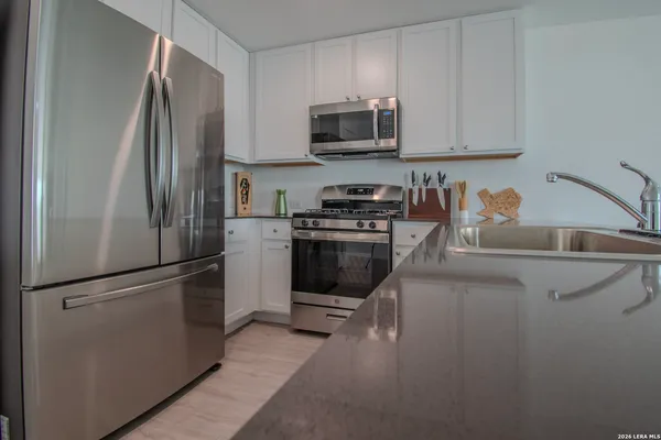 a kitchen with stainless steel appliances granite countertop a refrigerator and a stove