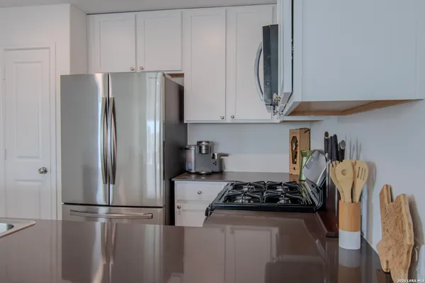 a kitchen with stainless steel appliances granite countertop a refrigerator a stove a microwave and sink