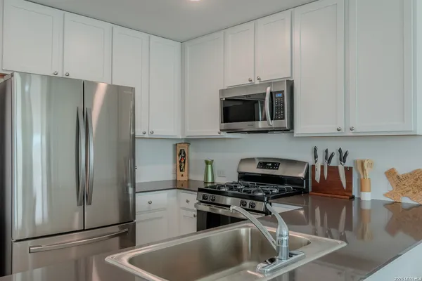 a kitchen with stainless steel appliances a refrigerator and a stove top oven