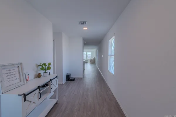 a view of a hallway with wooden floor and windows