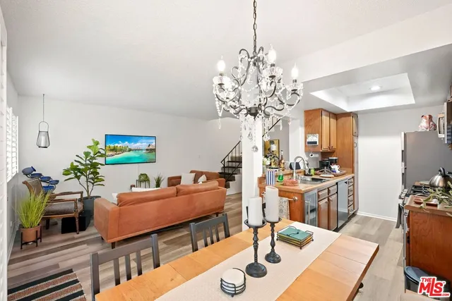 a living room with furniture chandelier and kitchen view