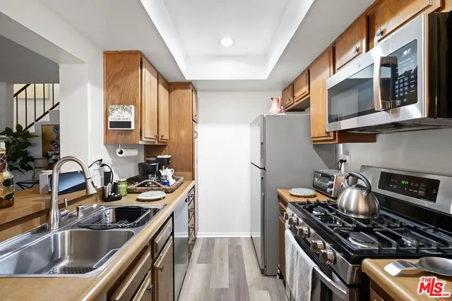 a kitchen with stainless steel appliances a sink a stove and a refrigerator