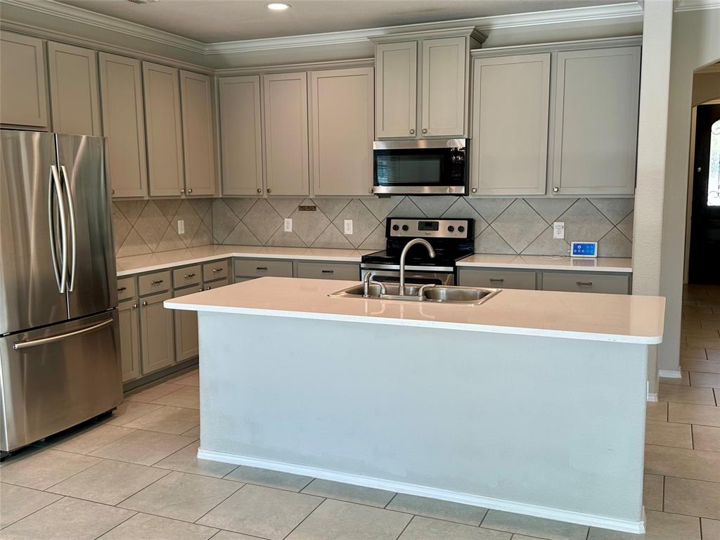 3716 Fossil Tree Lane Fort Worth, TX 76244 - Photo 7 of 30 a kitchen with stainless steel appliances a refrigerator a sink a stove a microwave and cabinets