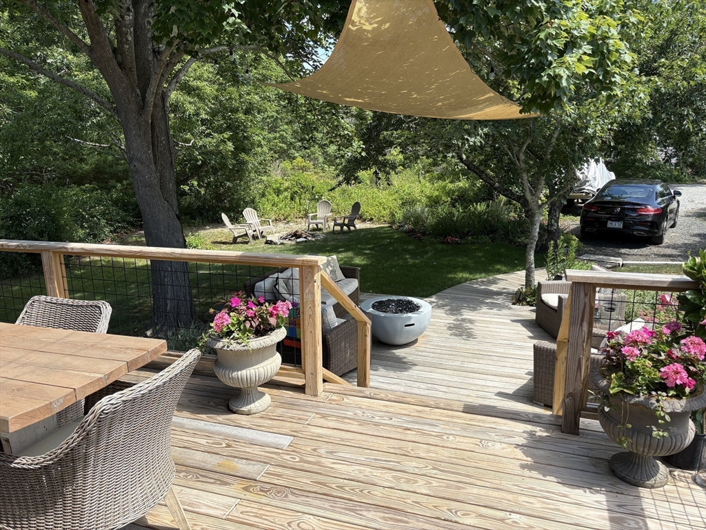4 R Old County Road Rockport, MA 01966 - Photo 22 of 29 a view of a patio with table and chairs potted plants and a palm tree