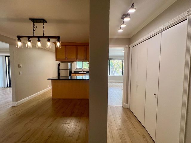 a view of a hallway with wooden floor and chandelier