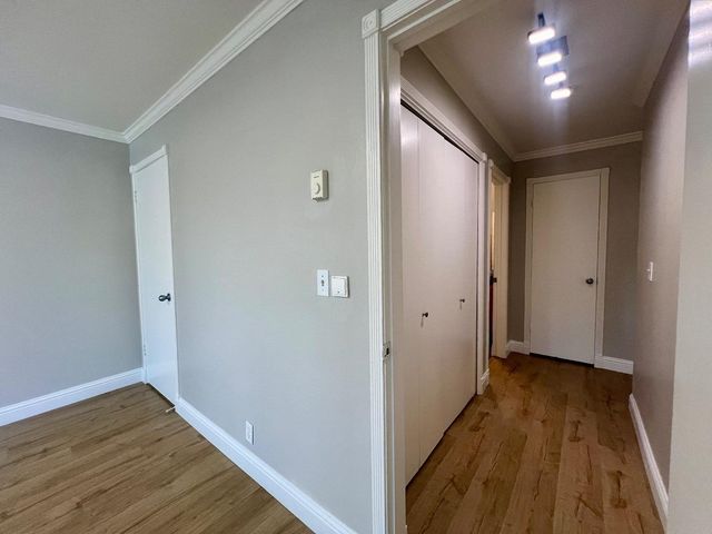 a view of hallway with wooden floor