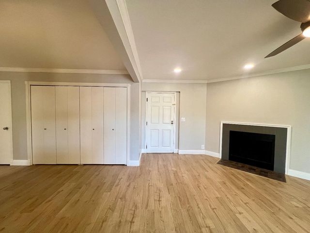 a view of empty room with wooden floor and fireplace