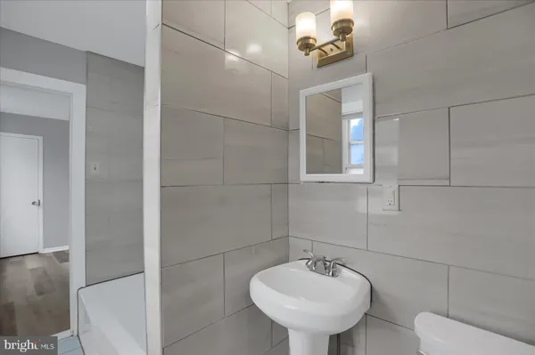 a bathroom with a sink a toilet and mirror