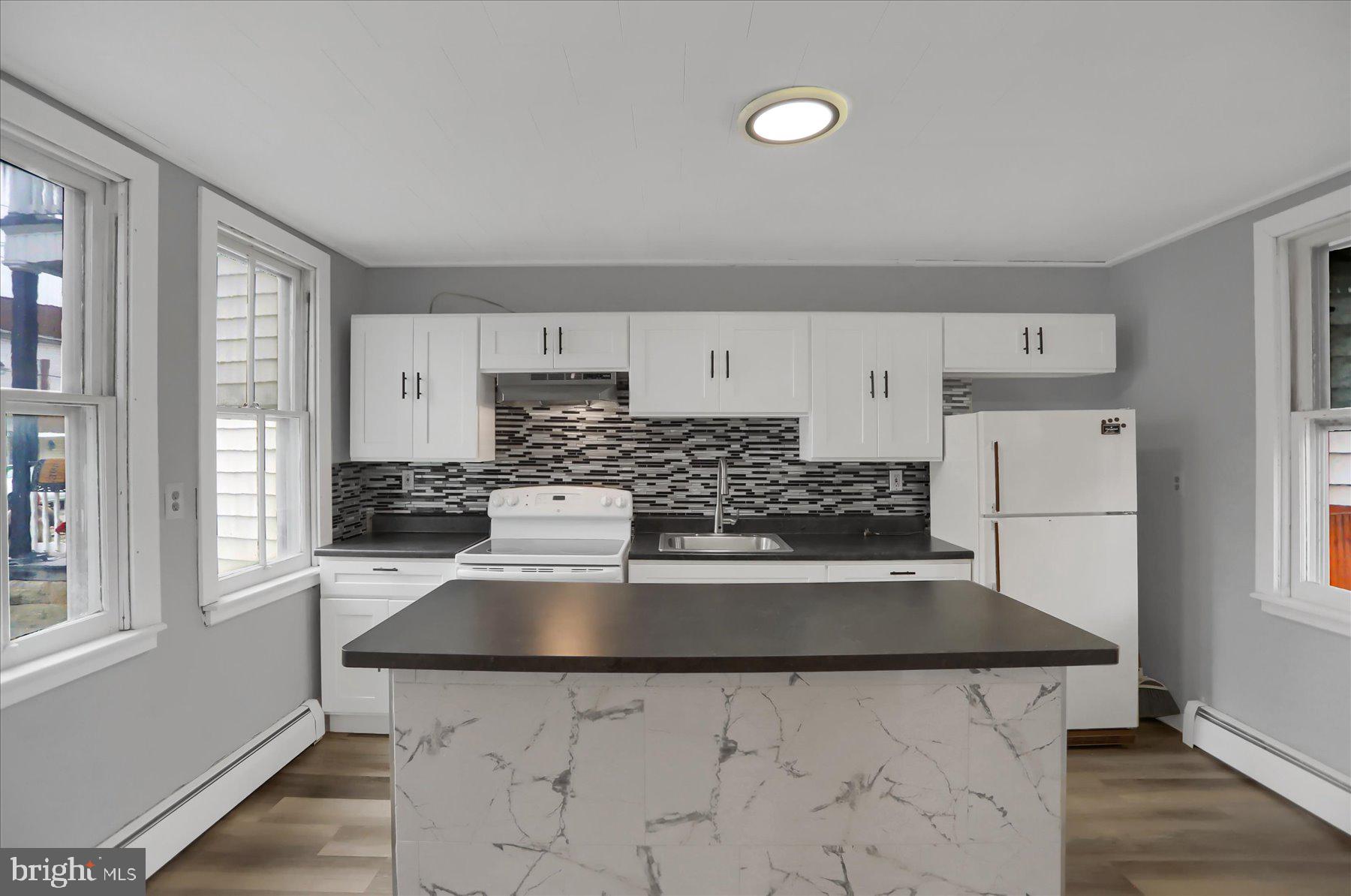 114 South 5th Street Shamokin, PA 17872 - Photo 7 of 25 a kitchen with a stove a refrigerator and white cabinets