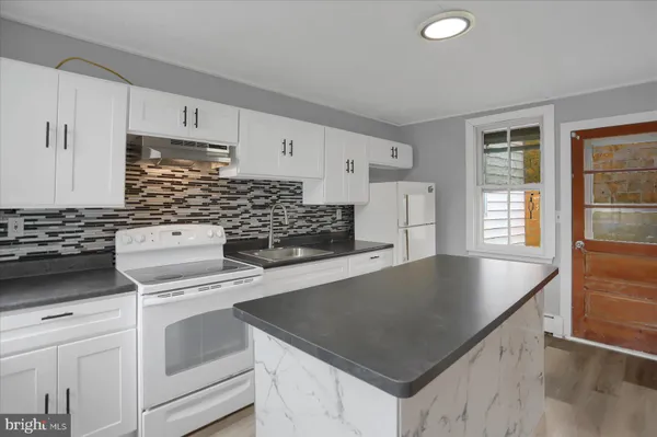 a kitchen with white cabinets and white appliances