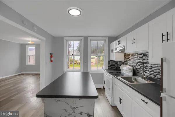 a kitchen with stainless steel appliances a sink stove and cabinets