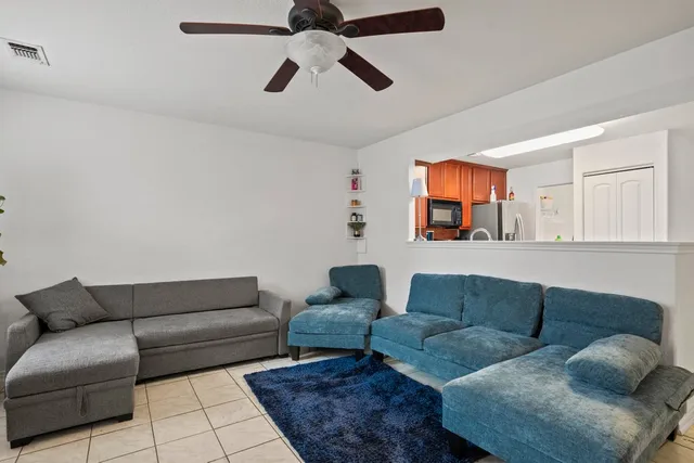 a living room with furniture and a ceiling fan
