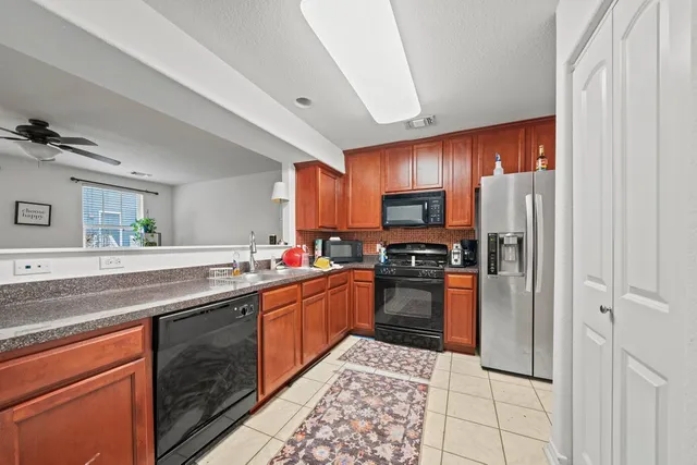 a kitchen with stainless steel appliances granite countertop a refrigerator and a sink
