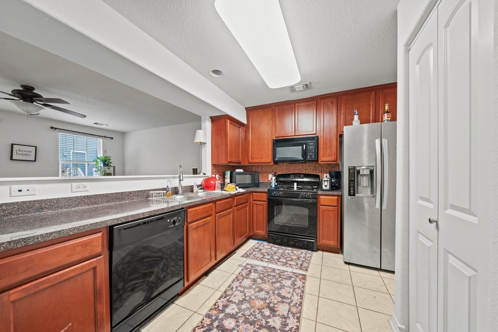 246 Trestle Tree San Marcos, TX 78666 - Photo 6 of 14 a kitchen with stainless steel appliances granite countertop a refrigerator and a sink