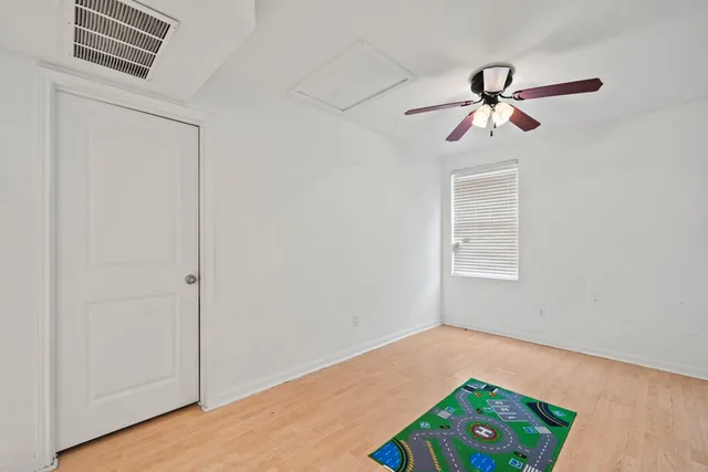 a view of room with a ceiling fan and wooden floor