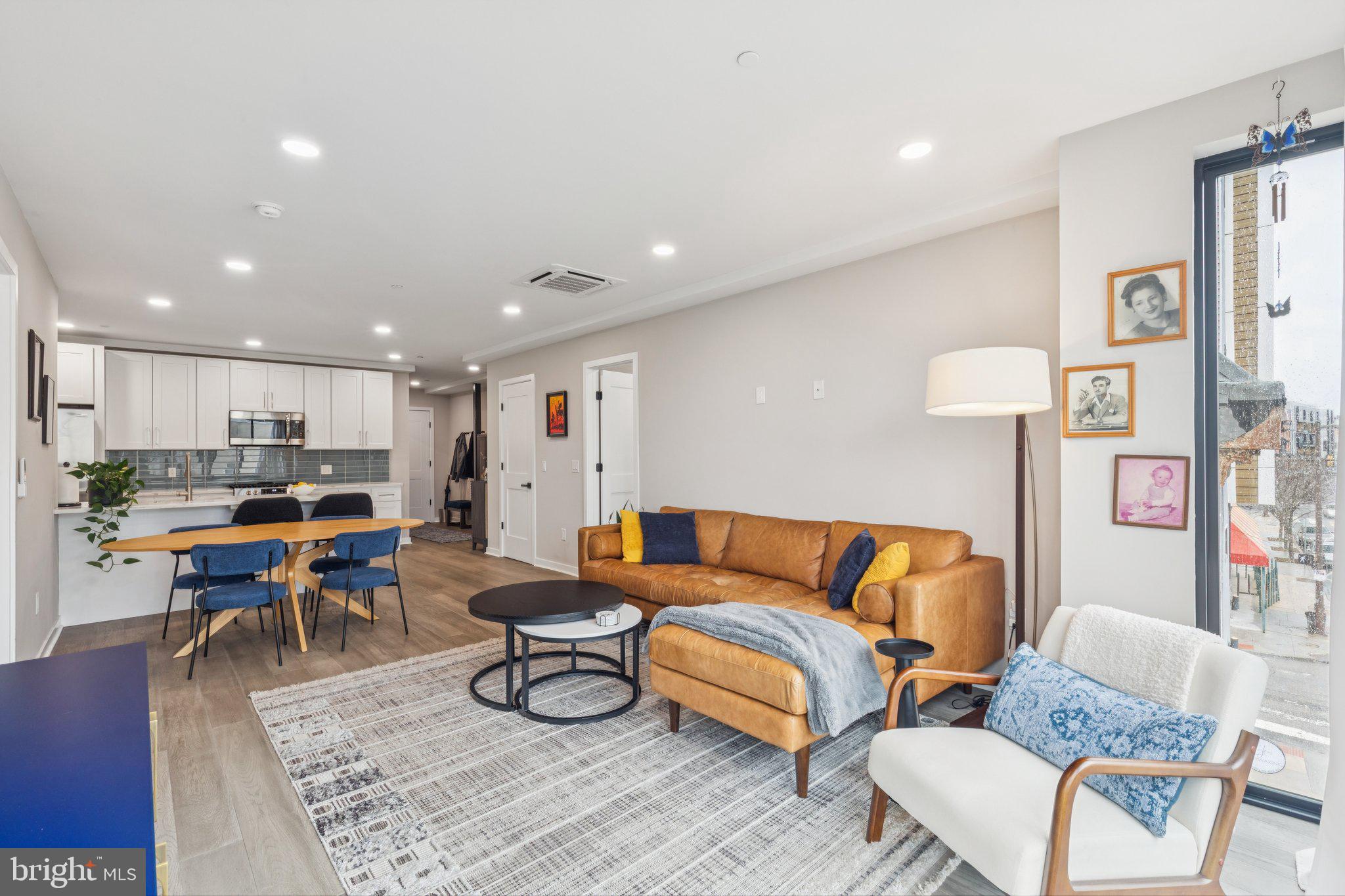 1648-50 Ridge Avenue, Unit 301 Philadelphia, PA 19130 - Photo 16 of 37 a living room with furniture a rug and a kitchen view