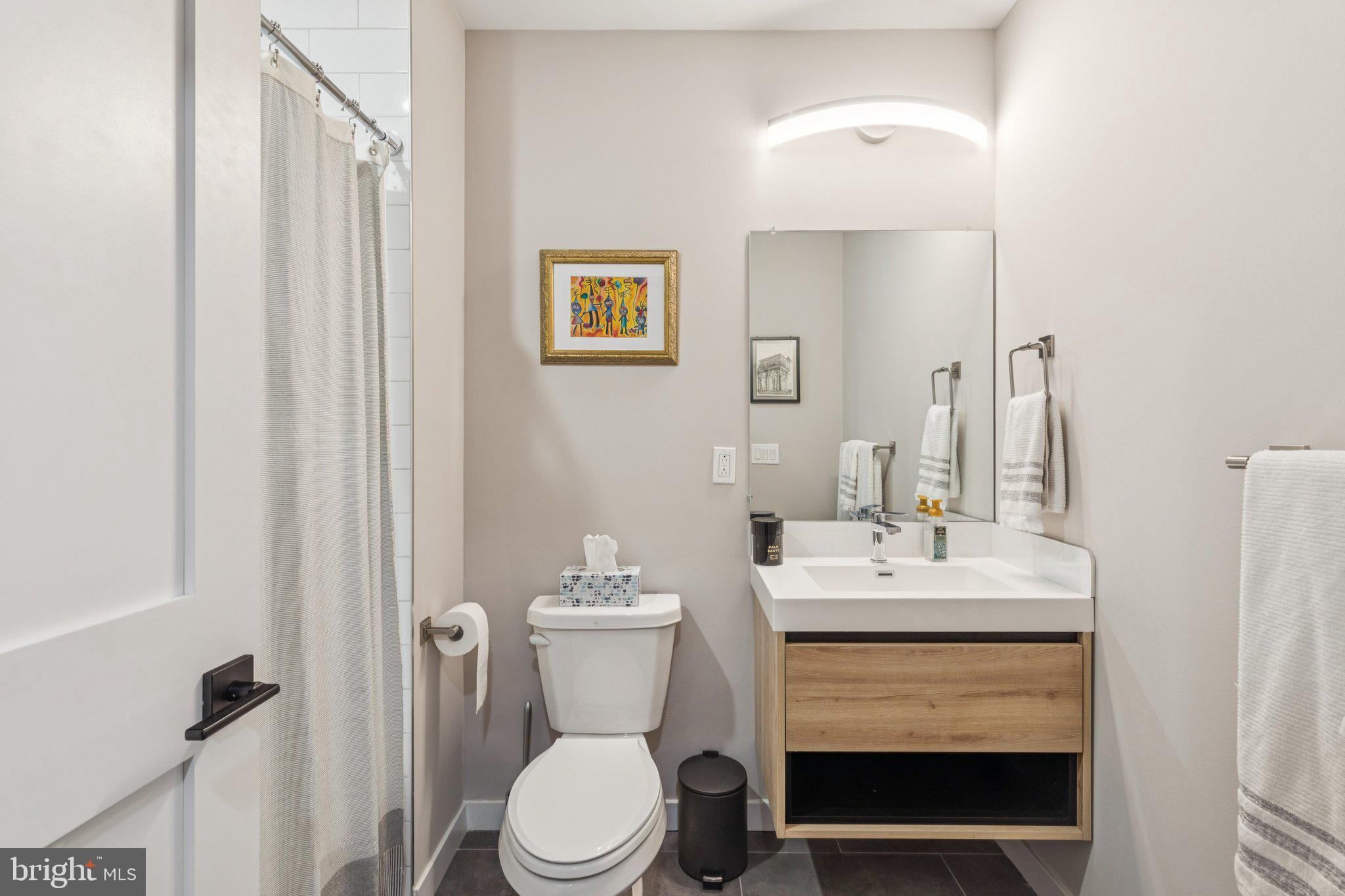 1648-50 Ridge Avenue, Unit 301 Philadelphia, PA 19130 - Photo 21 of 37 a bathroom with a sink toilet and mirror