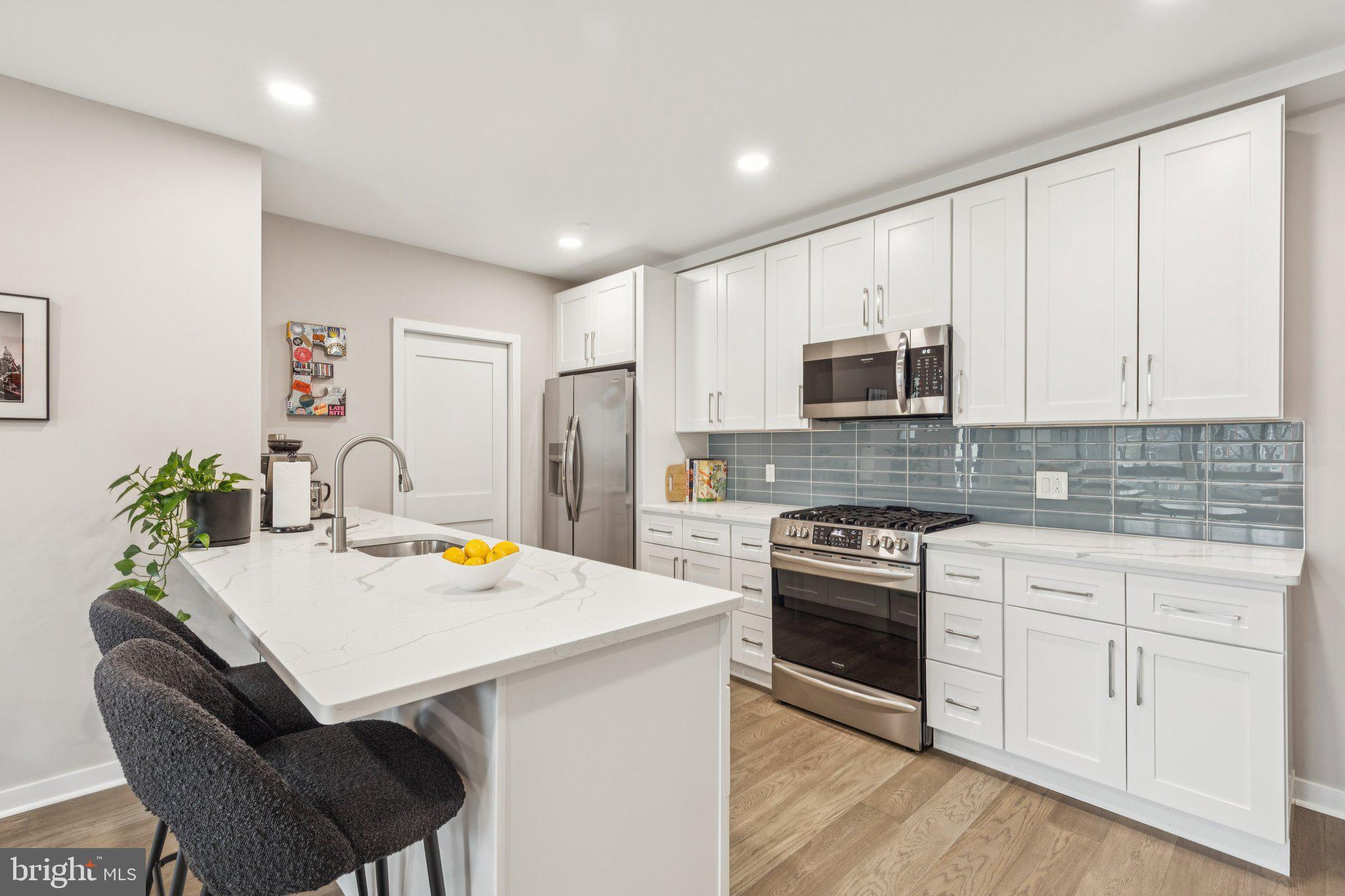 1648-50 Ridge Avenue, Unit 301 Philadelphia, PA 19130 - Photo 9 of 37 a kitchen with stainless steel appliances a stove a sink a microwave a refrigerator and white cabinets