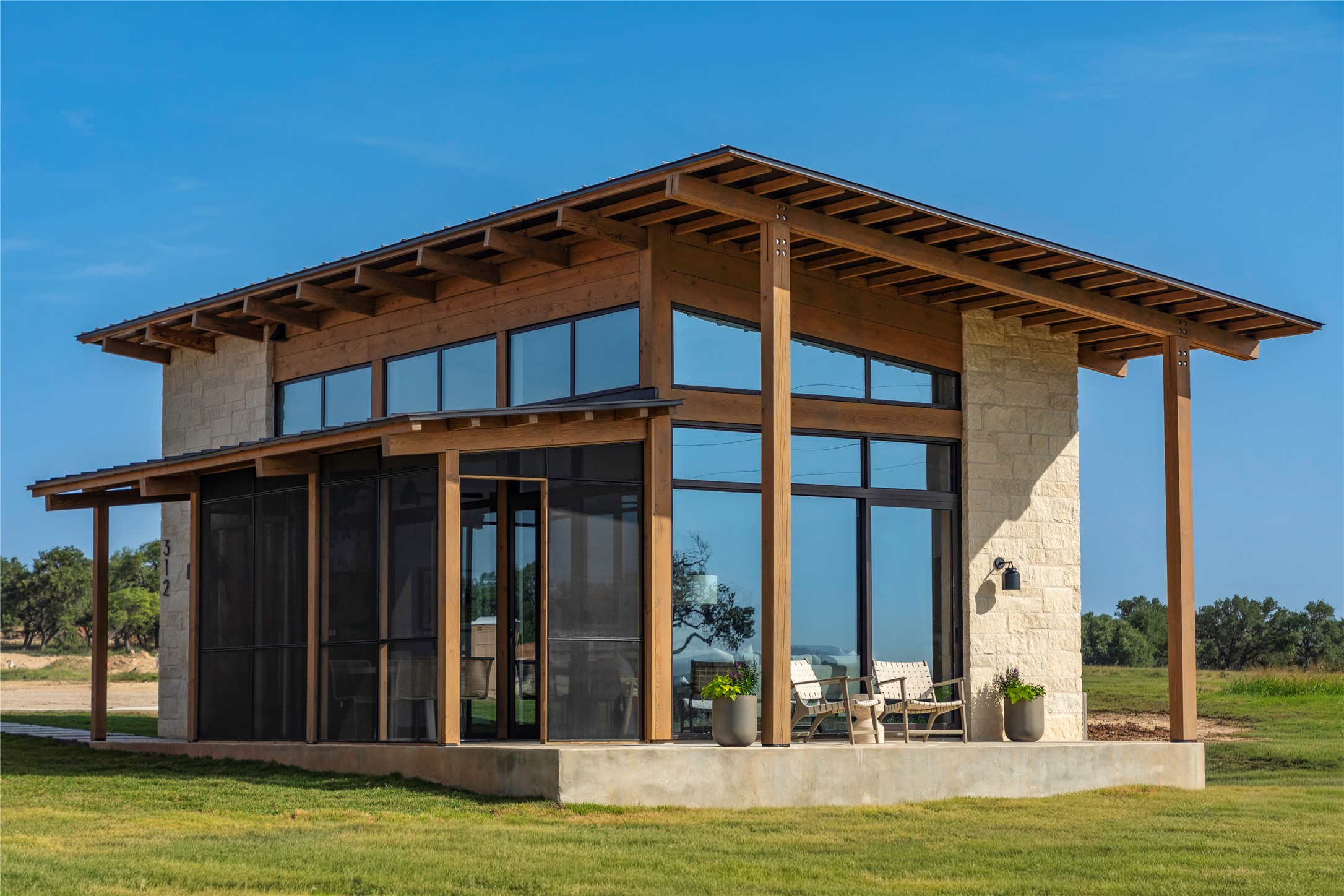 312 Hye Springs Road, Unit 106 Hye, TX 78635 - Photo 9 of 17 Crafted with wood and stone, this contemporary home boasts walls of windows and a screened porch.