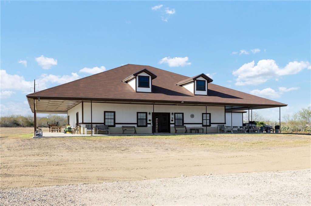2991 North Us Highway Roma, TX 78584 - Photo 4 of 28 Rear view of property featuring a large porch and a carport