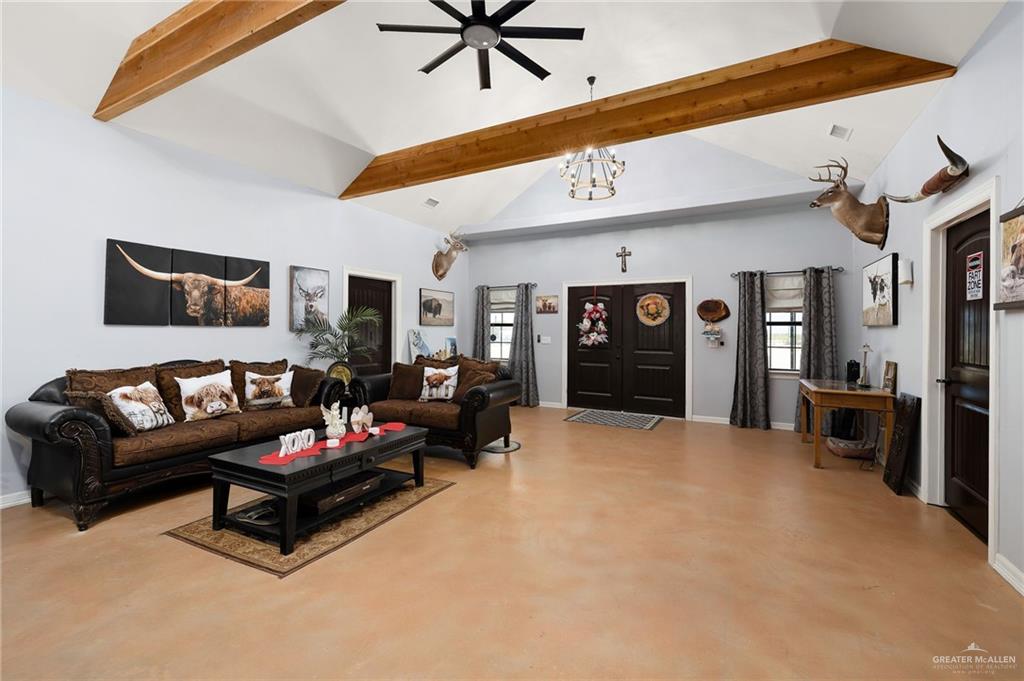 2991 North Us Highway Roma, TX 78584 - Photo 6 of 28 Living area featuring high vaulted ceiling, concrete floors, beamed ceiling, a chandelier, and a ceiling fan
