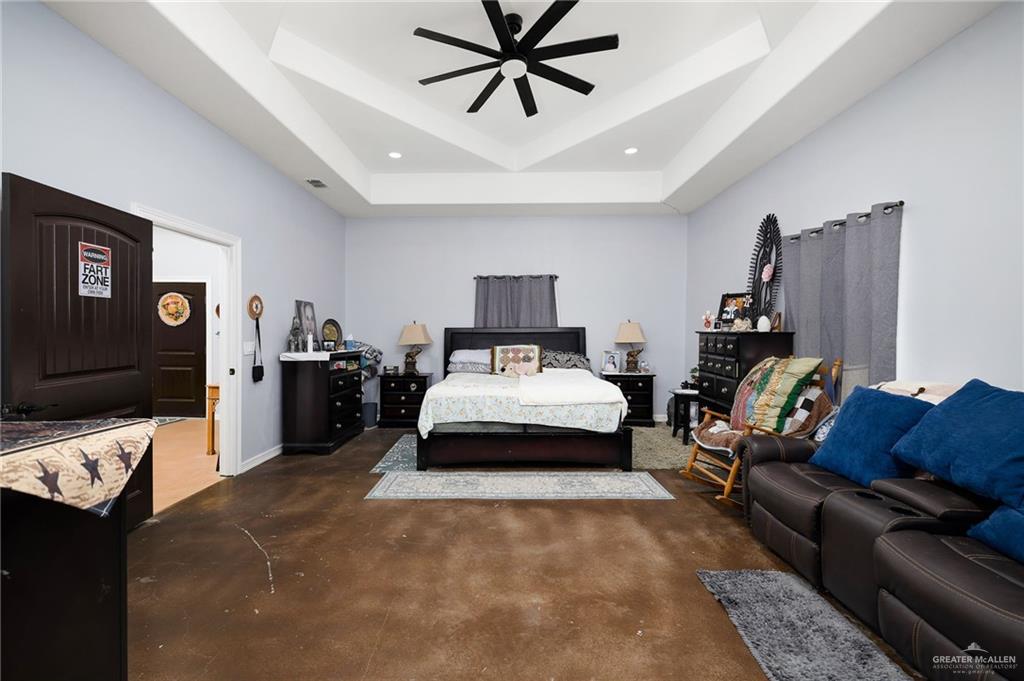 2991 North Us Highway Roma, TX 78584 - Photo 9 of 28 Bedroom with concrete floors, a ceiling fan, and a raised ceiling
