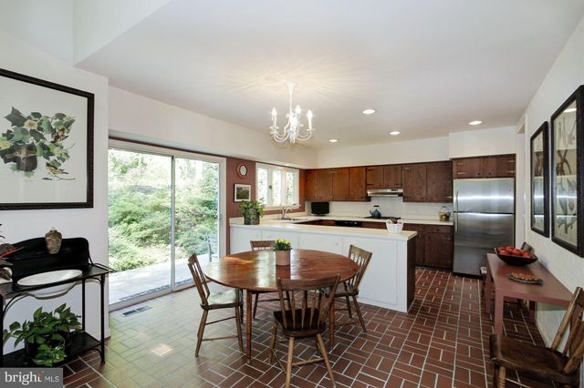 a kitchen with a table chairs refrigerator and microwave